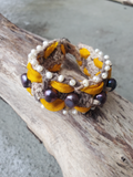 The base of this fiber bracelet is crocheted with a greyish hemp cord.  I thread the yellow Sari silk ribbon though the eyelets on both sides of the base, hand stitched tiny white pearls long the edges, and larger peacock pearls along the center.