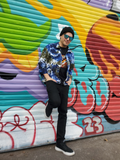same, but Rob is leaning against a very colorful graffiti door