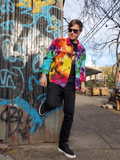 same, styled differently; Rob is standing atthe corner ofthe graffiti wall, he has one leg up pressed against the wall