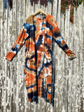 Tie-dye cardigan hanging on a wooden fence