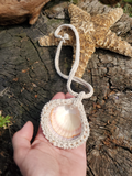 I'm holding the pendant, back up, showing all the crochet work