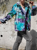 Showing the front, unbuttoned, rolled sleeves, a style photo against a grey wall