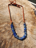 8" long lapis lazuli freeform disc beads attached to leather ties with brass rings