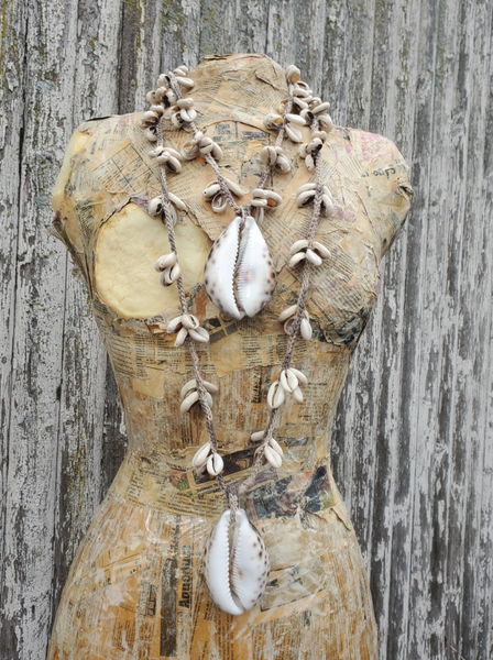 Your choice of a 24" or 40" long hemp crocheted necklaces with clusters of Cowrie shells, and a large tiger shell pendant. Displayed on a form