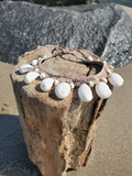 a beach photo- placed on a driftwood piece, surrounded by sand and a grey rock