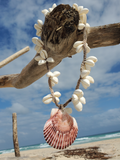 a mood shot; the necklace is hanging on a dry branch, with the blue ocean behind