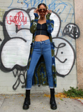 A cool style photo; frontal shot, Mariana is holding her sunglasses with both hands. Her thumbs are sticking through the holes, you can't really see much of the cardigan, the sides are hanging on her side.