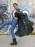 In motion, a side shot, lifting one leg up, looking at the camera, , she's holding out the sides  out - the cardigan is floating behind her.