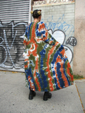 Back view of the long cardigan, Mariana has her hands in the side pockets.