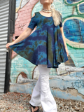A feminine swing style cold shoulder tunic, a size small modeled by me; I'm holding out one side of the top to show how much fabric this style has