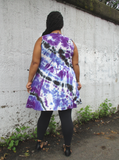 A back shot; Mu's hands are holding the dress on the side. She has a pair of black leggings and sandals on