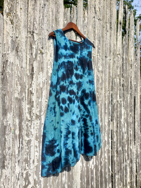 Blue tie-dye dress hanging on a wooden post