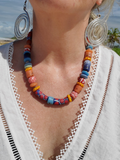 Colorful beaded necklace worn by a person with a scenic background
