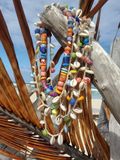 Colorful beaded necklaces with shell elements on a wooden surface