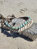 Bracelet with amazonite and shelkl beads on a sandy surface