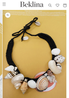 Necklace with shell beads on a yellow background, brand 'Beklina.com' visible