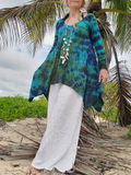 Person wearing a blue and green tie-dye shirt with white pants standing under palm trees on a beach.