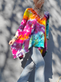 Person wearing a colorful tie-dye shirt with a blurred background