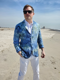 Man wearing a blue ice dye blazer and sunglasses on a beach