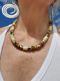 Necklace with colorful beads worn by a person against a blue sky background