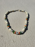 Necklace with decorativebone and stone beads on a sandy surface