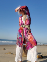 I'm wearing a colorful ice-dye open front cardigan on a beach with clear blue sky