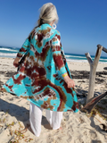 Person wearing a tie-dye kimono on a beach