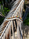 Beaded choker on a dried palm leaf with natural background