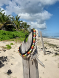 colorful choker on a wooden post aainst the beach