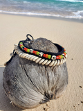 beaded shell necklace placed on a coconut at the beach