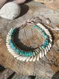 Necklace with turquoise and white beads on a wooden surface