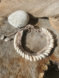 The backside of a Necklace with shell beads on a wooden surface