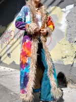 Person wearing a colorful jacket with fur trim against a graffiti-covered wall.