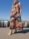 woman wearing a long earthy colored sleeveless dress at the beach