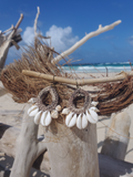 Decorative wreath with shells and driftwood on a beach
