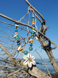 photographed on a dry branch, with the ocean in the background