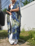 Person wearing a tie-dye kimono over a white outfit outdoors.