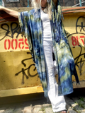 Person wearing a colorful scarf in front of a graffiti-covered wall