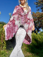 Person wearing a pink tie-dye kimono in a natural setting with trees and blue sky.