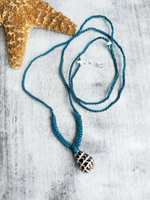 crocheted with a waxed turquoise cord, adjustable necklace with a decorative shell pendant on a textured surface Hebrew Cone shell