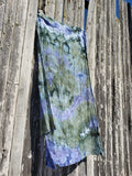 big green blue scarf is hanging on a fence