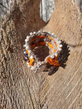 Bracelet with orange and silver elements on a wooden surface