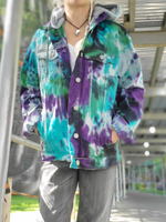 a closer front view of the jacket, unbuttoned, rolled sleeves, hands in pockets. The pretty tie dye colors are called NORTHRERN LIGHTS  - purple-green-jade-a bit of black over the light colored denim garment