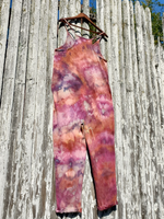 Colorful tie-dye jumpsuit hanging on a wooden fence