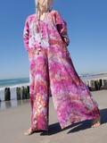 Person wearing a colorful tie-dye outfit on a beach