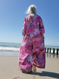 Person wearing a pink floral kimono on a beach
