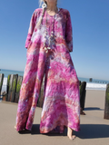 Person wearing a colorful tie-dye outfit on a beach