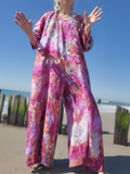 Person wearing a colorful floral outfit on a beach