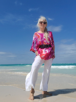With the blue waves behind me, I'm wearing a black belt over the short kaftan tunic