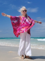 A vibrant ice dye short kaftan in purple-pink-oj colors. Photographed in Punta can, at the beautiful Caribbean Sea